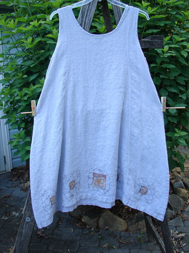 Barclay Linen Pocket Pinafore Mosaic Floral Lavender Size 0 on clothesline, showcasing A-line flair, scoop neckline, and double drop exterior pockets, crafted from lightweight linen with mosaic floral design.