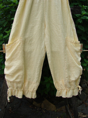Barclay Linen Tie Bottom Pocket Bloomer Buttercup Size 1 displayed on a clothesline, showcasing elastic waist, exterior drop pockets, and blooming lowers with pull ties, embodying Bluefishfinder.com's vintage, creative style.