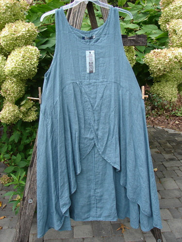 Barclay NWT Linen Tulip Midlayer Overpiece Unpainted La Mer Size 0 on hanger, features layered front, scoop neck, flowy silhouette, displayed outdoors against wooden trellis with green shrubs and hydrangeas.