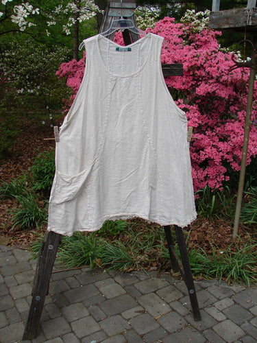 Barclay Slub High Vent Figure 8 Lace Pocket Pinafore Dress Unpainted Crème Size 2 hanging on a clothesline outdoors, showcasing its unique figure-eight seams, drop side pockets, and lacy hem accents.