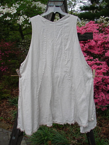 Barclay Slub High Vent Figure 8 Lace Pocket Pinafore Dress Unpainted Crème Size 2 hanging on a clothesline, showcasing its unique figure-eight seams, A-line shape, and lace accents around the hemline.