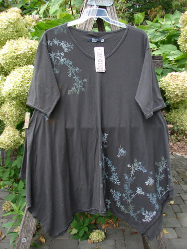 Barclay NWT Origami Tunic Top Floral Branch Black Sand Size 0: Asymmetrical hem, loose fit, charcoal-gray with pale blue-gray floral motif, oval neckline, raw edges, on hanger outdoors.