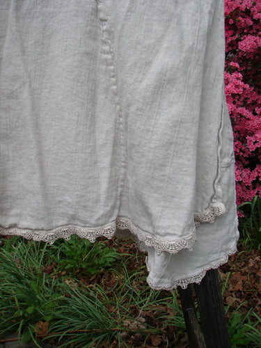 Close-up of Barclay Slub High Vent Figure 8 Lace Pocket Pinafore Dress Unpainted Crème Size 2, highlighting unique figure-eight seams, drop side wrap pockets, and lacy hem accents.