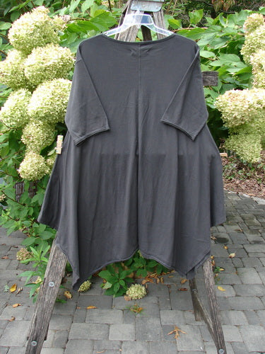 Barclay NWT Origami Tunic Top Floral Branch Black Sand Size 0, featuring an oversized fit, elbow-length sleeves, handkerchief hem, oval neckline, and floral branch design, draped outdoors over a wooden ladder.