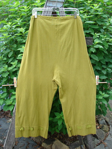 Barclay Bow Bottom Pantaloon Unpainted Green Olive Size 0 hanging on a clothesline, showcasing its full elastic waistline, flat textured ribbon bows, and buttonhole accents at the cuffs.