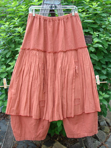 Barclay Hemp Linen Batiste Fusion Pant Skirt Autumn Harvest Size 0 hanging outdoors on a clothesline, showcasing its unique triangular patches, double tie accents, and slightly tapered, sectional paneled under pant.