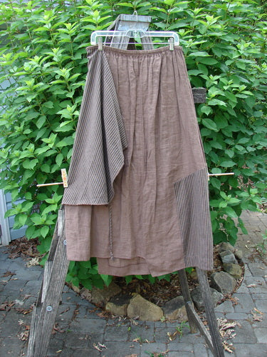 Barclay Linen Every Way Apron Skirt Stripe Mocha Size 0 displayed on a wooden ladder, showcasing its full elastic waistline, striped side apron, and exterior stitchery.