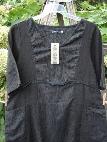 Barclay NWT Linen Pucker Heart and Soul Pocket Dress Unpainted Black Size 0 features a scooped neckline, elbow-length sleeves, front patch pockets, and textured-seam design, hanging on a clear hanger.