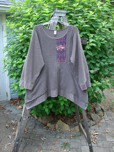 Barclay Patched Crepe Perennial Tunic Top Woods Bark Size 1, featuring a patchwork design, downward curved empire waist, and front drop wrap side pockets, displayed on a swinger.