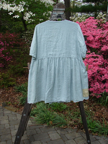 1999 Linen Adjustable Wrap Dress Butterfly Water OSFA displayed on a stand outdoors, featuring a wrap-around style, empire waistline, flouncy skirt, and butterfly print center wrap.