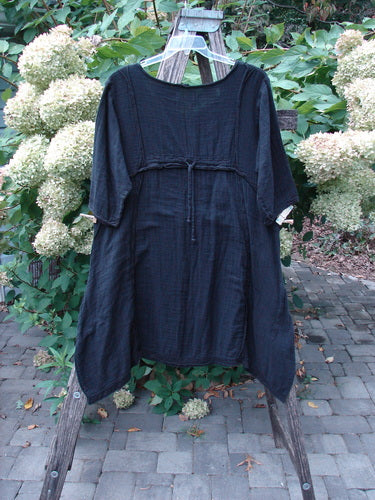 Barclay NWT Gauze Daily Pocket Dress Unpainted Jet Black Size 0 features a loose fit with elbow-length sleeves, an empire waist tie, and distinctive rolled edges, hanging on a wooden stepladder.