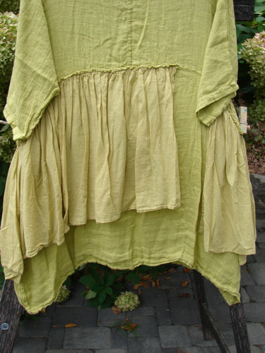 Barclay NWT Gauze Batiste Petal Urchin Flounce Dress in Citron, featuring a wide scooped neckline, three-quarter sleeves, and tiered ruffled design, hanging outdoors, embodying Bluefishfinder.com's vintage, creative spirit.