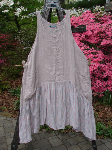 Barclay Gauze Batiste Peasant Jumper Unpainted Stripe Mallow Size 2 hanging on a clothesline, showcasing its full cotton gauze upper, batiste stripe lower, and unique hemline with exterior wrap pockets.