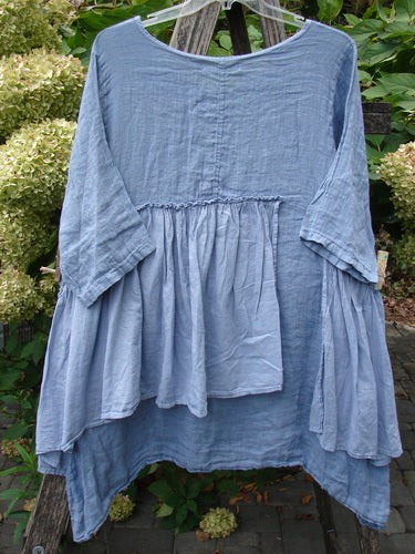Barclay NWT Gauze Batiste Petal Urchin Flounce Dress Unpainted Dusty Sky Size 1, featuring a loose fit with gathered waist and drapey hem, elegantly displayed on a hanger.