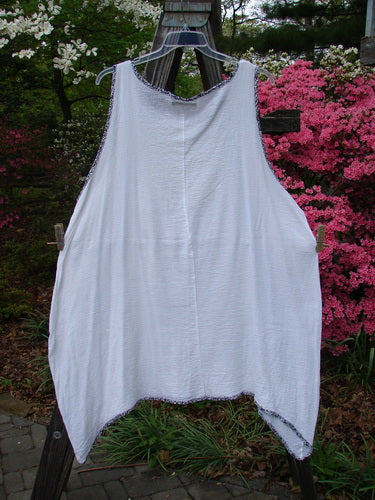 Barclay Crinkle Gauze Contrast Ditsy Daisy Pinafore Unpainted White Size 2 hanging on a clothesline, showcasing its scoop neckline, deep arm openings, and floral hem accents.