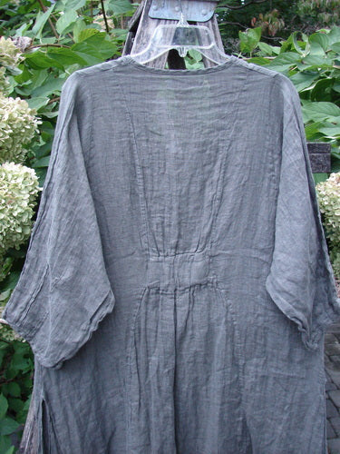 Barclay NWT Linen High Vent Venetian Dress Farm Dark Caper Size 1, featuring an oval neckline, pinched sleeves, curvy panels, and tall side vents, displayed on a hanger against a natural backdrop.