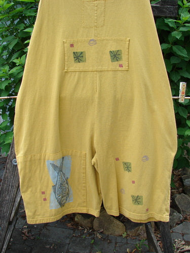 Close-up of the 1991 Farmer Brown Overall Pant Jumper Vintage Fish Goldenrod OSFA, showcasing detailed fish patterns on yellow fabric, dual stacked painted pockets, and generous shoulder straps from Bluefishfinder.com.