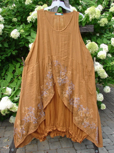 A Barclay Linen Open Front Drawcord Hem Jumper in Squash, featuring a brown dress with a floral design on a clothesline.
