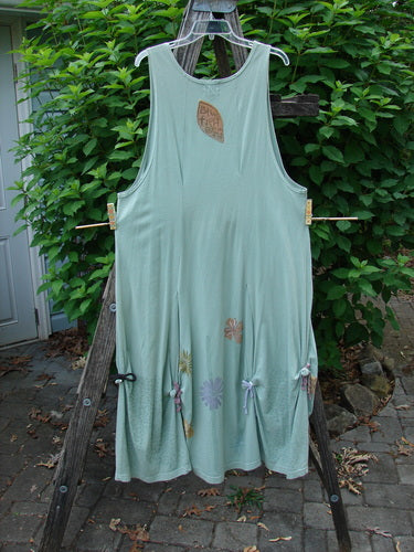 Barclay Constellation Jumper Garden Folly Aloe Size 1 displayed on a clothesline, highlighting its deeply scooped neckline, pointed hem accents, and unique button rippie gather detailing.