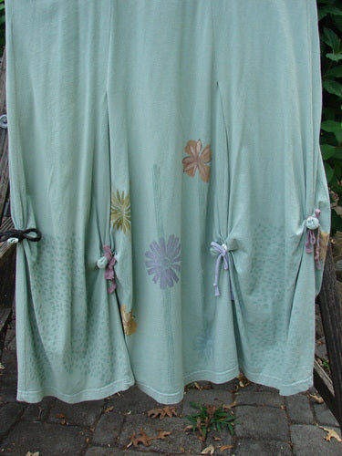 Barclay Constellation Jumper Garden Folly Aloe Size 1, featuring a deeply scooped neckline, dimensional hemline with pointed accents, and vertical panels, displayed outdoors, highlighting its unique design elements.