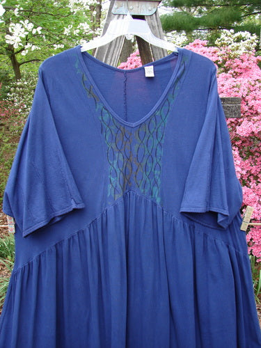 Barclay Short Sleeved Dubuffet Dress Spirograph Royal Size 2 displayed on a clothes rack, showcasing its dramatic pointed hemline and spirograph-themed design with three-quarter length sleeves.