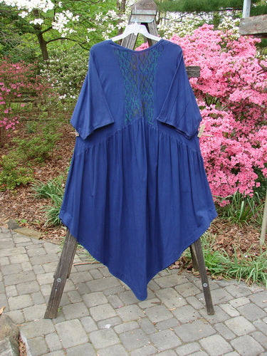 Barclay Short Sleeved Dubuffet Dress Spirograph Royal Size 2 displayed on a rack, highlighting its dramatic pointed hemline and gathered front with three-quarter length sleeves and vertical pinched seams.