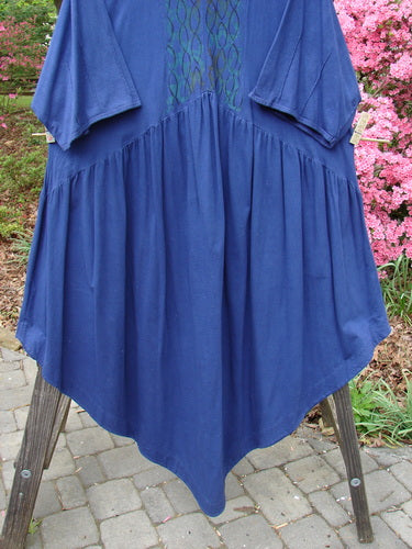 Barclay Short Sleeved Dubuffet Dress Spirograph Royal Size 2 displayed on a rack, showing its flowing design, gathered front, pointed hemline, and three-quarter length sleeves with pinched seams.