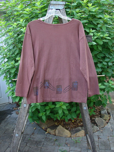 Barclay Long Sleeved Studio Tee Celtic Wind Loam Size 0 displayed on a wooden rack, highlighting its straight boxy shape and thinner neckline, reflecting Bluefishfinder.com's vintage and whimsical style.