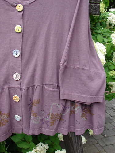 Close-up of the Barclay Peplum Pocket Jacket Magic Garden Dusty Plum Size 2, featuring ceramic buttons, peplum hem, and three-quarter sleeves with elbow bellow, showcasing the intricate painted garden theme.