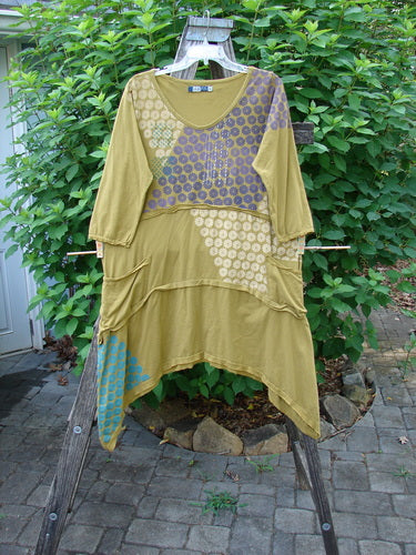 Barclay Raw Seam Vector Tunic Dress in Sectional Daisy Yellow Olive hangs prominently, showcasing fluttery edges, raw seams, and exterior drop pockets, reflecting Bluefishfinder.com's unique vintage style.