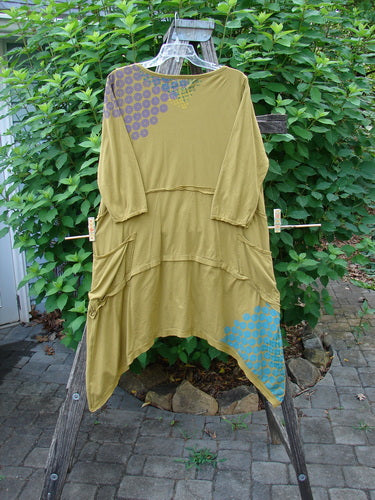 Barclay Raw Seam Vector Tunic Dress Sectional Daisy Yellow Olive Size 0 displayed on a clothes rack, showcasing its unique raw edges, V-shaped neckline, and distinctive fluttery stitch detailing.