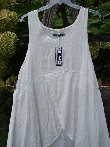 Barclay NWT Linen Tulip Midlayer Overpiece Unpainted White Size 0 displayed outdoors on a hanger, showcasing its asymmetrical front overlap, slightly crinkled fabric, and sweeping A-line flare.