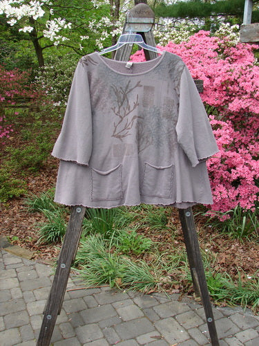 Barclay Fleece Cafe Sweatshirt Poet Garden Shaunting Stone Size 2 displayed on a wooden stand, showcasing its rounded neckline, exterior front cargo pockets, and flared hemline with curly edgings.