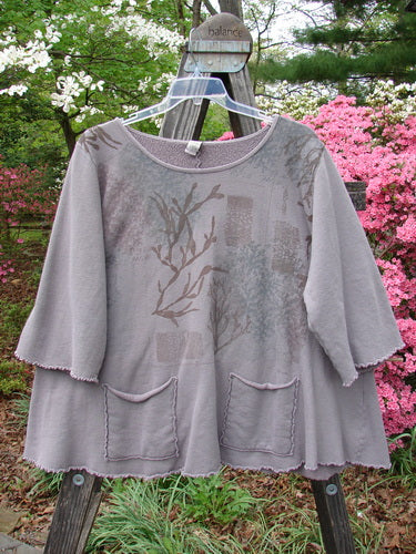 Barclay Fleece Cafe Sweatshirt Poet Garden Shaunting Stone Size 2 displayed outdoors on a hanger, showcasing rounded neckline, three-quarter sleeves, and front cargo pockets with intricate curly edgings.