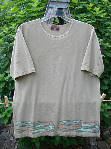 Barclay Short Sleeved Tee Stone Path Border Wheat Size 1 displayed on a clothes rack, showcasing its rounded neckline, short sleeves, and straight wide shape with distinctive stone path border detailing.