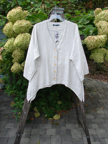 Barclay NWT Linen Basque Cardigan Unpainted Dove Size 0, featuring a deep V-neck, asymmetrical hem, three-quarter sleeves with wide cuffs, and oversized shell buttons, elegantly draped on a wooden hanger.