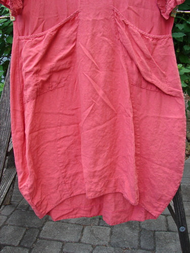 Barclay Linen Ceremony Tea Thostle Dress Summer Unpainted Geranium Size 0 displayed on a wooden ladder, showcasing its hourglass shape, offset pleated pockets, and lower bell three-quarter length pleated sleeves.