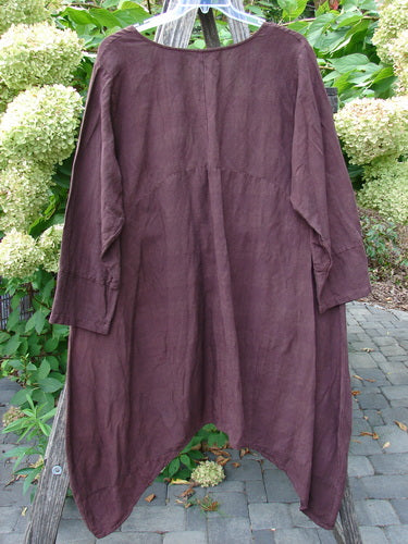 Barclay NWT Linen Geoides Pocket Duster features a loose fit, asymmetric hem, and wide scoop neckline, made from medium-weight linen blend, hanging outdoors on a hanger against a natural backdrop.