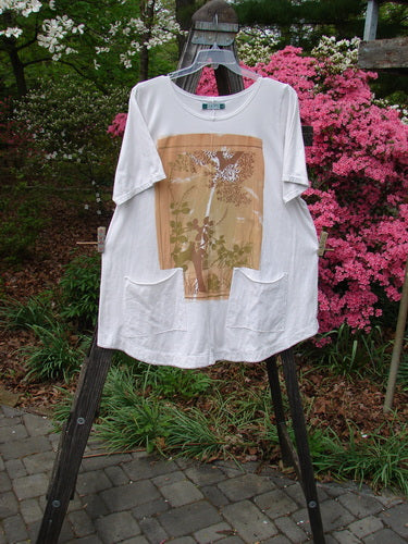 Barclay Short Sleeved Two Pocket Twinkle Top features a rounded neckline, short wide sleeves, front pockets, and a tree design, perfect for expressing individuality with vintage-inspired style.