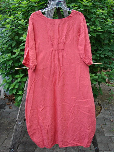 Barclay Linen Ceremony Tea Thostle Dress Summer Unpainted Geranium Size 0 features a scooped neckline, hourglass shape, upward scoop hemline, and bell sleeves, elegantly displayed on a wooden ladder outdoors.