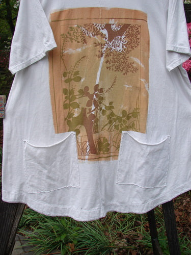 Barclay Short Sleeved Two Pocket Twinkle Top with leaf and fern design, rounded neckline, and short wide sleeves. Made from medium weight organic cotton, size 2.