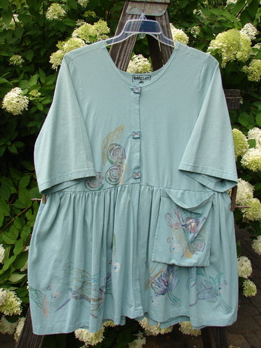 Barclay Flower Garden Tunic Dress Dragonfly Aloe Size 2, featuring a light blue floral design, ceramic buttons, pleated skirt, sweeping A-line shape, and an external painted pocket on a swing.