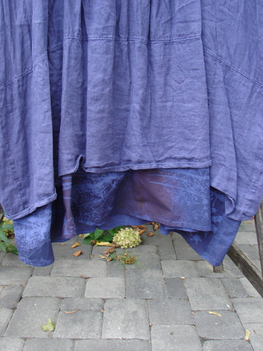 Barclay NWT Linen Process Two Story Dress Mum Ultra Violet Size 0, featuring a textured, layered design with a matte indigo outer and shiny purple percale underskirt, draped over a stone walkway.