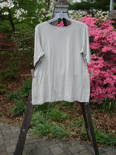 Barclay Three Quarter Sleeved Textured A Line Tee Wild Cat Live True Cloud Size 2 displayed on a clothes rack, showcasing its organic cotton texture and unique design features.