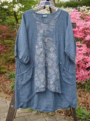Barclay NWT Linen Posey Tunic Buttercup Patch Blue Echo Size 2, displayed on a clothes rack, highlighting its lightweight, flowy linen fabric, oversized pockets, and three-quarter sleeves.