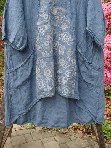 Barclay NWT Linen Posey Tunic Buttercup Patch Blue Echo Size 2 draped on a wooden ladder, showcasing its A-line shape, oversized slant pockets, and three-quarter sleeves.