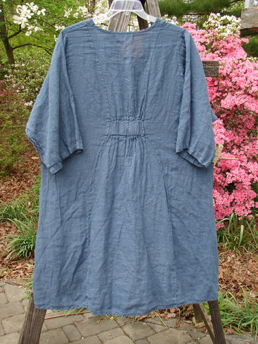 Barclay NWT Linen Posey Tunic Buttercup Patch Blue Echo Size 2 displayed on a clothes rack, showcasing its oval neckline, three-quarter sleeves, and oversized pockets.