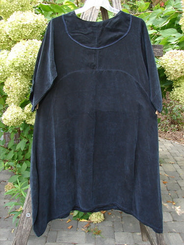 Barclay NWT Cupro Cross Over Urchin Dress in Primitive Metallic Black hangs elegantly on a ladder. The luxurious, velvet-like fabric features a loose-fitting design, embodying Bluefishfinder.com's vintage, expressive style.