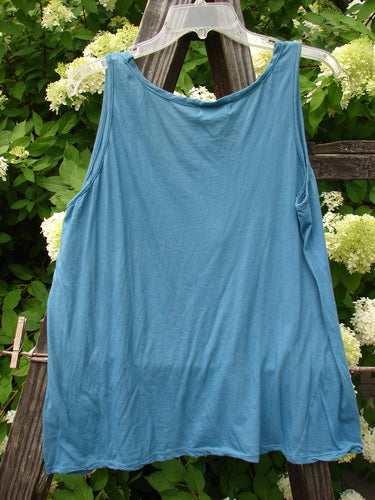 Barclay NWT Batiste Decora Tiny Tank Unpainted Peacock Size 2 hanging on a clothesline, showcasing its A-line shape, front vertical neckline tie, and gather detail.