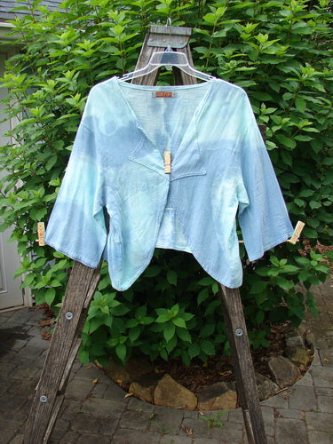 Barclay Gauze Open Front Shrug Mottled Sky Size 1 displayed on a wooden ladder, showcasing its three-quarter sleeves, open front design, and unique hemline, embodying Bluefishfinder.com's vintage, expressive style.